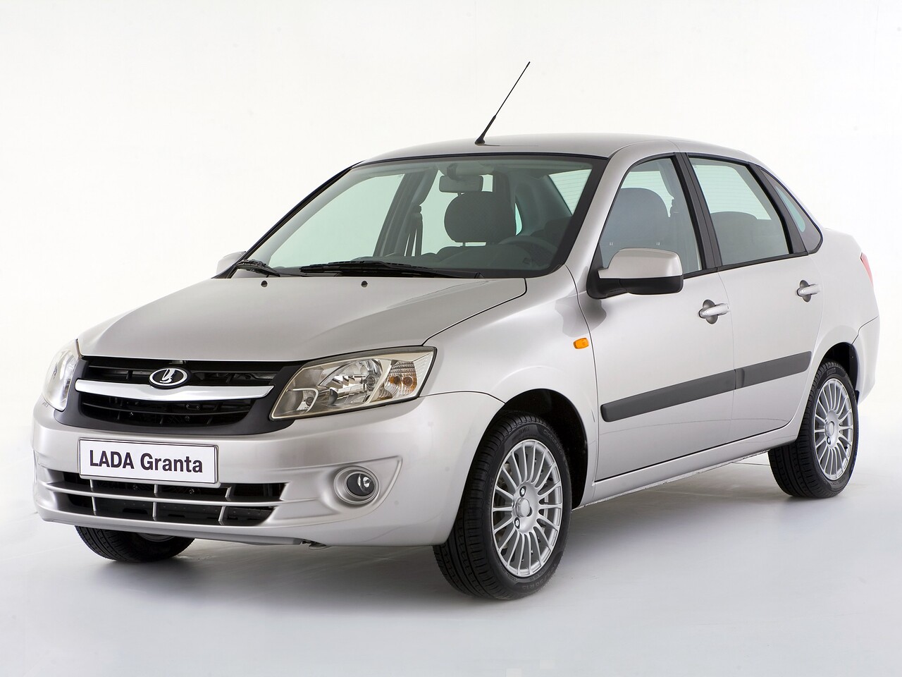 ВАЗ (Lada) Granta Седан (I поколение, 2011 - 2018 г.в.): Серебристый седан в студии, вид спереди сбоку