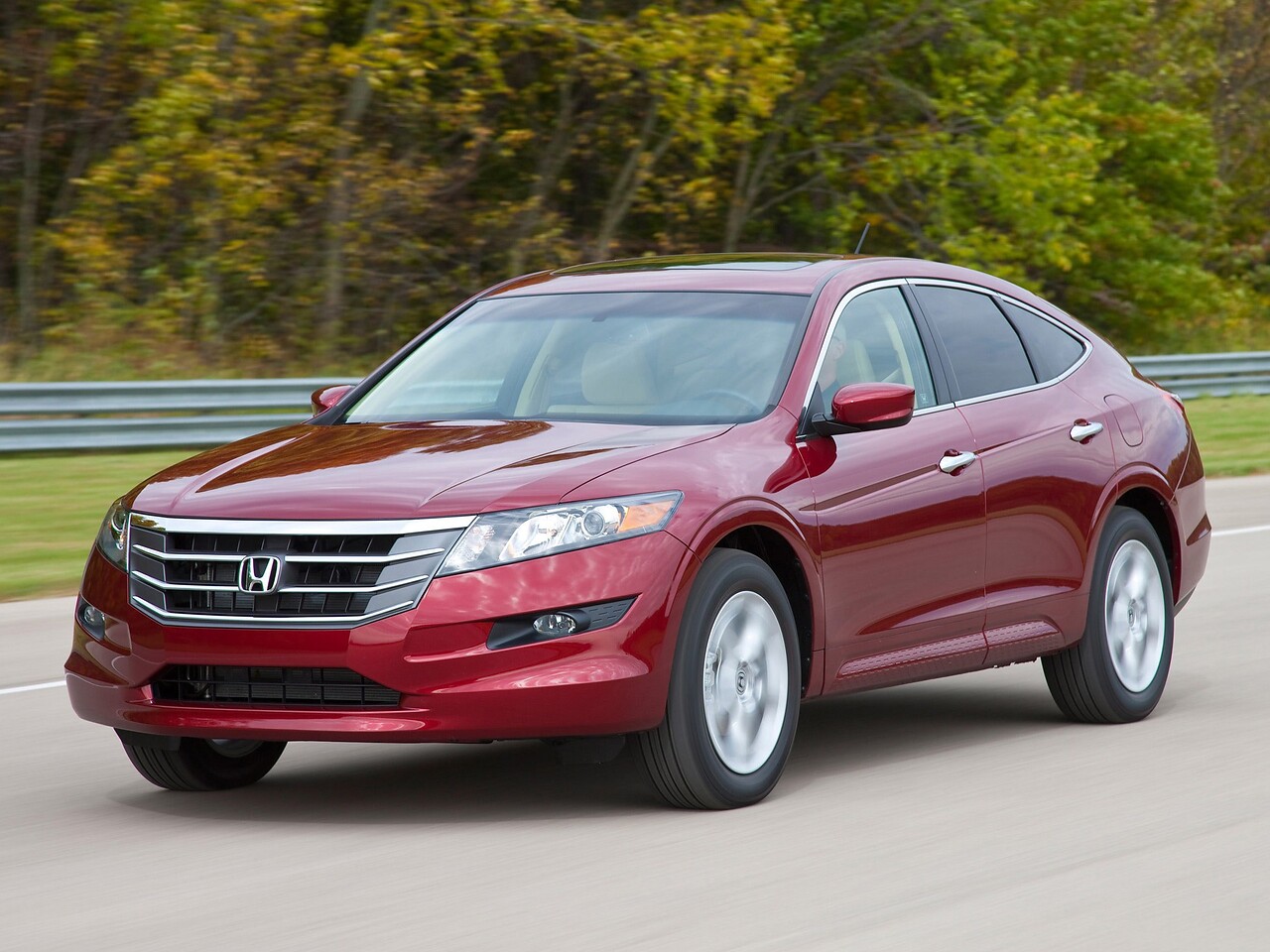 Honda Crosstour 3.5 MT Executive: Красный кроссовер на дороге среди осенних деревьев, вид спереди сбоку