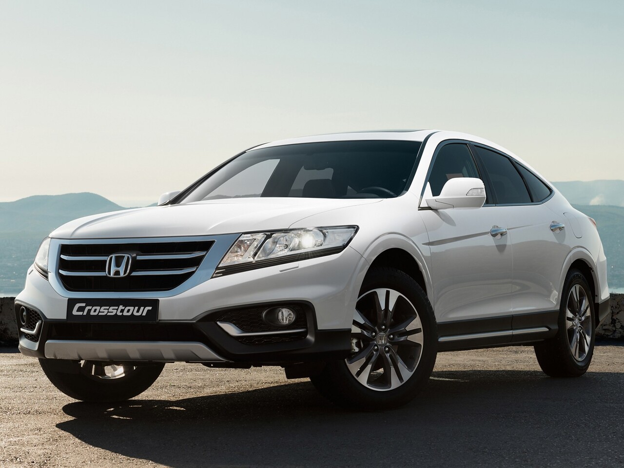 Honda Crosstour 3.5 AT Premium Navi: Белый кроссовер на дороге в сумерках на фоне гор, вид спереди сбоку