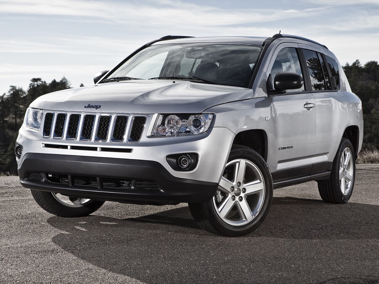 Jeep Compass (I поколение рестайлинг, 2011 - 2016 г.в.): Серебристый кроссовер в студии, вид спереди сбоку
