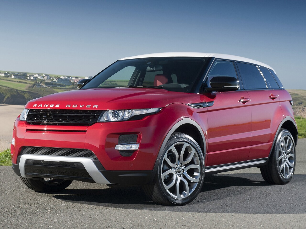 Land Rover Evoque 5-дв. (I поколение, 2011 - 2015 г.в.): Три четверти спереди на фоне прибрежного города