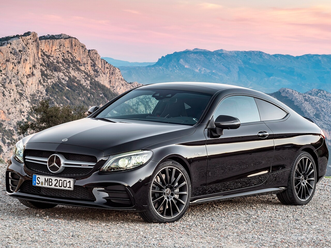 Mercedes-Benz C-класс купе 1.6 AT Sport (C 180): Три четверти спереди на гравии на фоне гор на закате