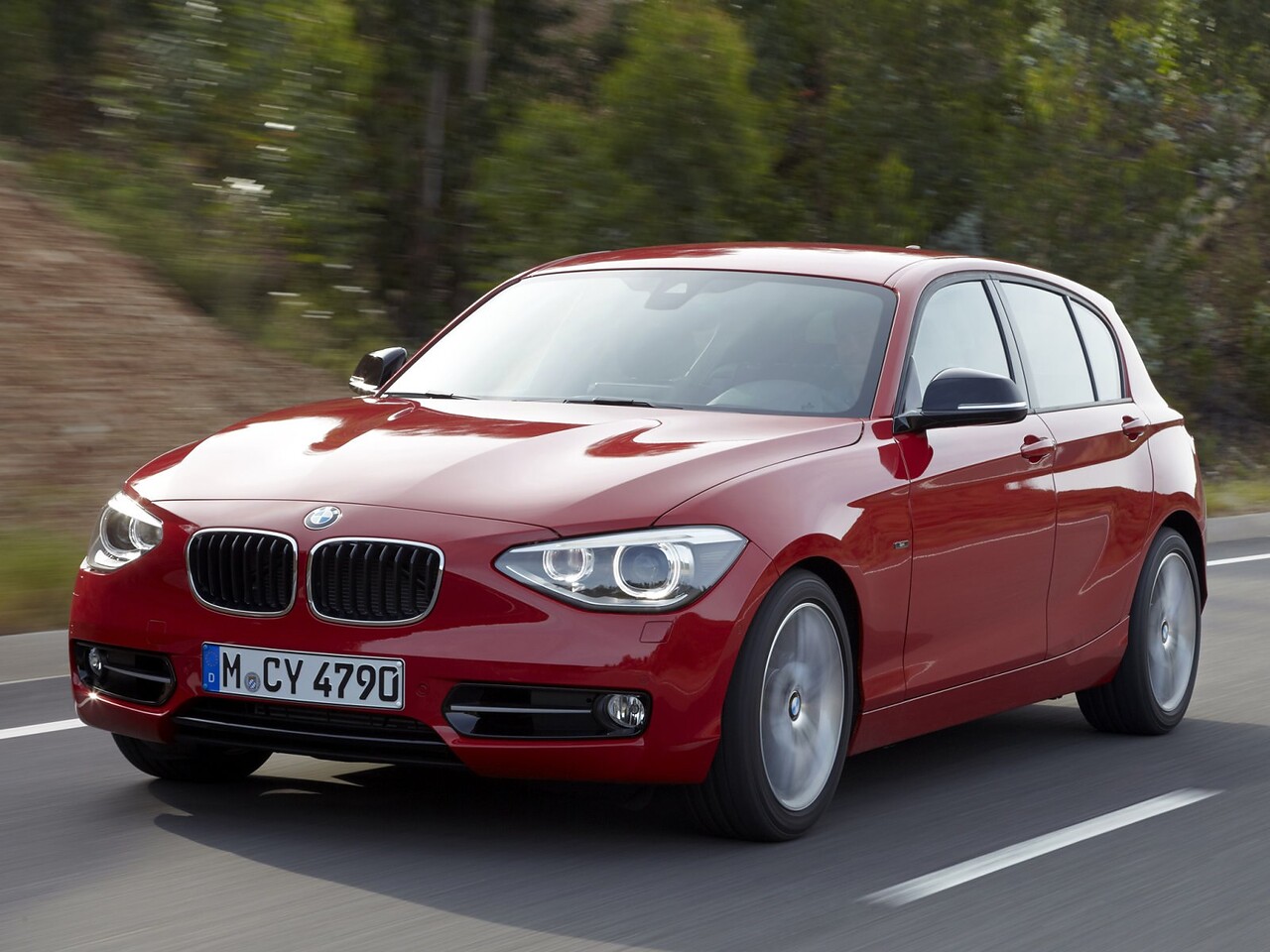 BMW 1-я серия хэтчбек 5-дв. 1.6 AT 118i (Sport): вид спереди сбоку на дороге