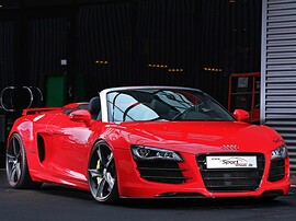 Audi R8 Spyder 4.2 FSI quattro AT: Три четверти спереди у здания, красный кузов
