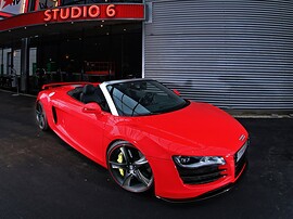 Audi R8 Spyder 4.2 FSI quattro AT: Три четверти спереди сверху у здания, красный кузов