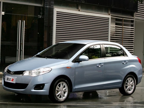 Chery Bonus (II поколение, 2009 - 2013 г.в.): Три четверти спереди у стеклянного здания, голубой кузов