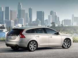 Volvo V60 (I поколение, 2010 - 2014 г.в.): Сзади три четверти на фоне города, серебристый кузов