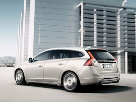 Volvo V60 (I поколение, 2010 - 2014 г.в.): Профиль у многоэтажного здания, серебристый кузов