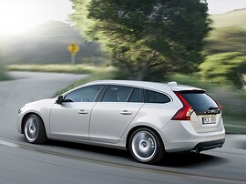 Volvo V60 (I поколение, 2010 - 2014 г.в.): Сзади три четверти на фоне холмов, серебристый кузов