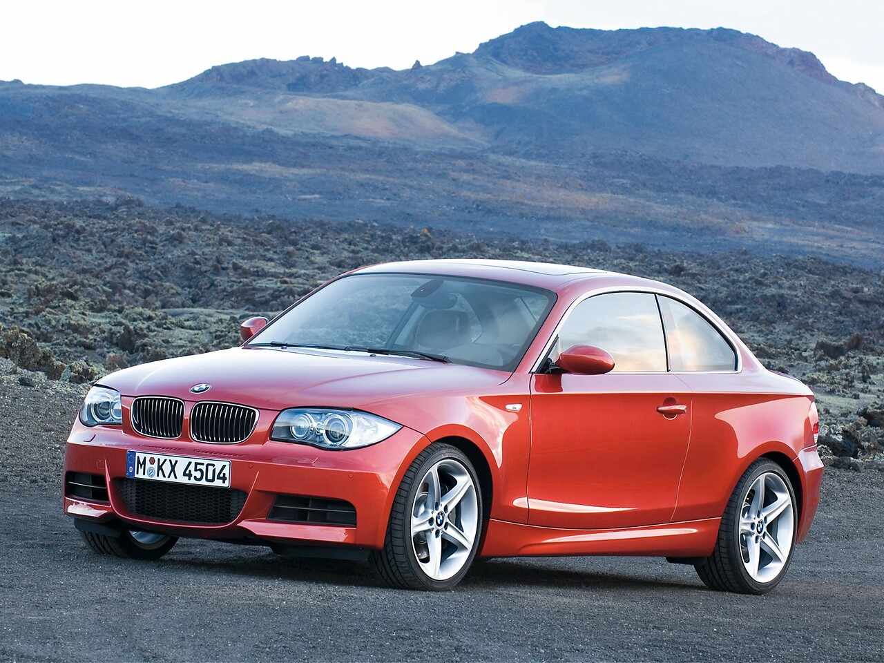 BMW 1-я серия купе 2.0d AT 120d: вид спереди сбоку на каменистой местности