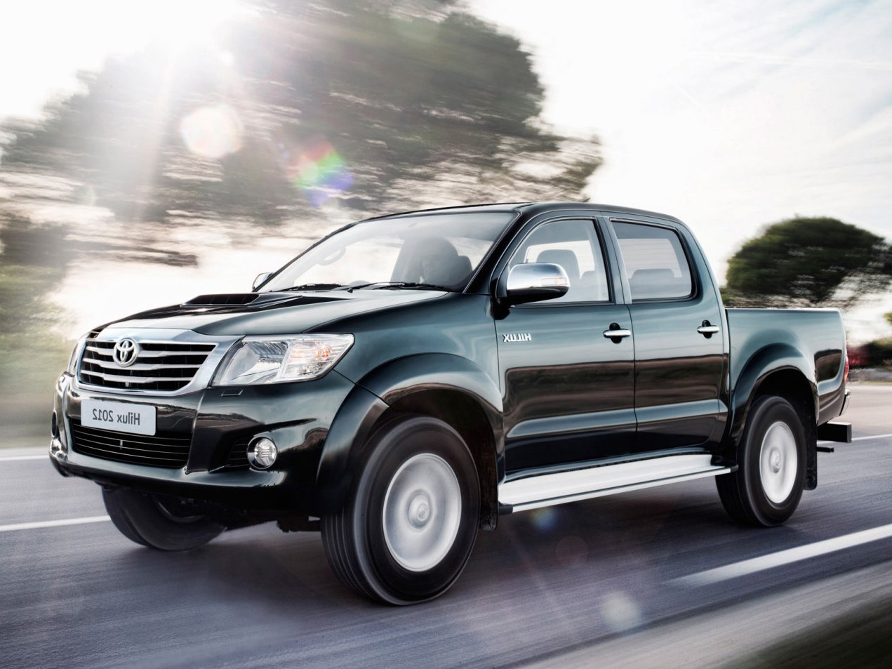Toyota Hilux 2.5d MT Элеганс: Три четверти спереди в движении, тёмно-зелёный кузов