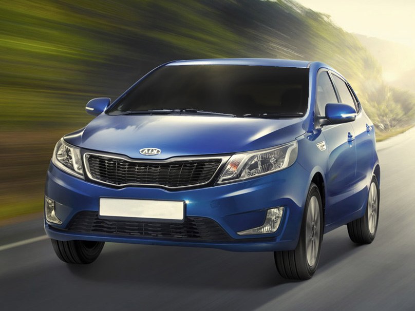 KIA Rio хэтчбек 5-дв. (III поколение, 2012 - 2015 г.в.): вид спереди сбоку на дороге