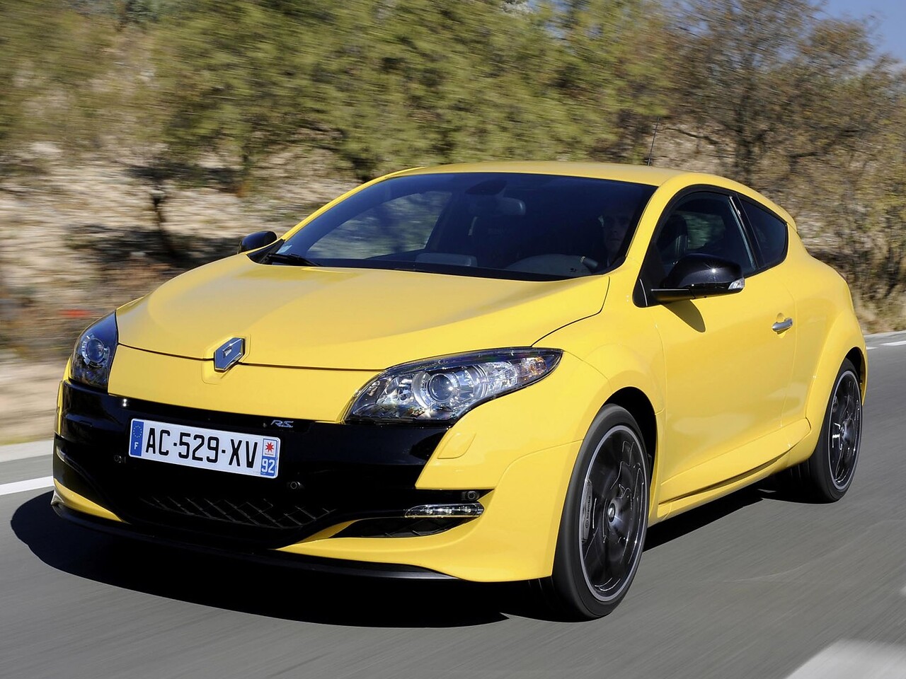 Renault Megane RS (III поколение, 2009 - 2013 г.в.): вид спереди сбоку на дороге