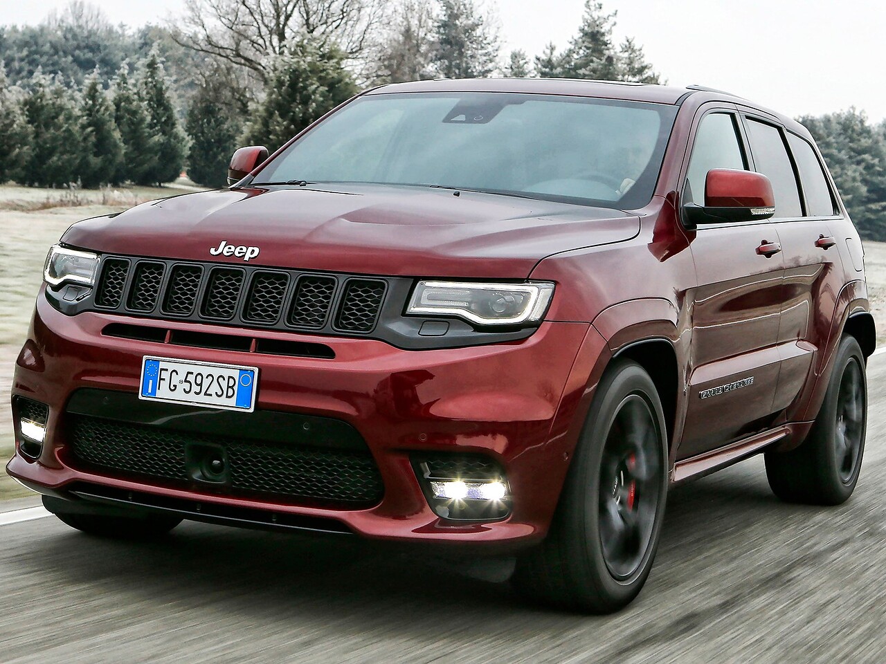 Jeep Grand Cherokee SRT8 (WK2 2-й рестайлинг, 2016 - 2022 г.в.): вид спереди сбоку у деревьев