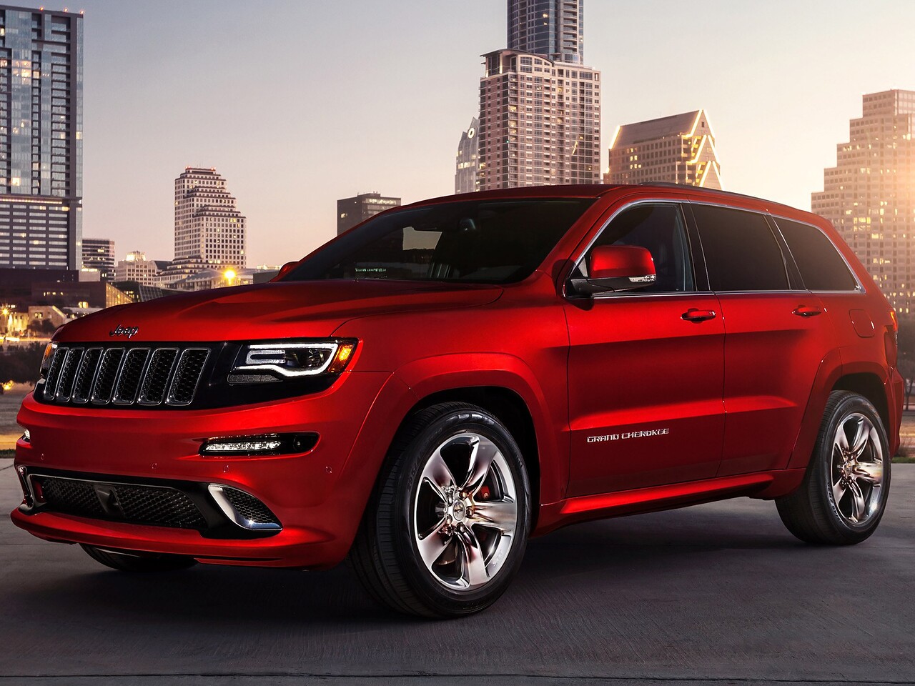 Jeep Grand Cherokee SRT8 (MK2 рестайлинг, 2013 - 2016 г.в.): вид спереди сбоку на фоне города