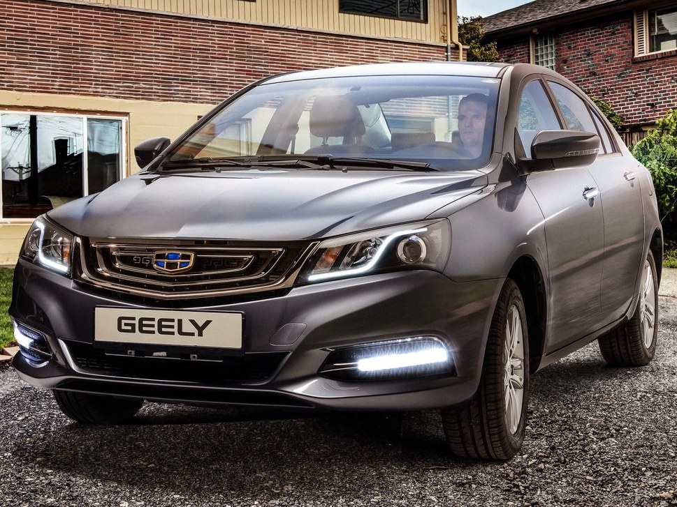 Geely Emgrand (I поколение 2-ой рестайлинг, 2018 - 2020 г.в.): вид спереди сбоку у здания