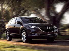Mazda CX-9 (I поколение рестайлинг, 2012 - 2015 г.в.): вид спереди сбоку на дороге
