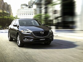 Mazda CX-9 (I поколение рестайлинг, 2012 - 2015 г.в.): вид спереди сбоку на дороге