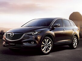 Mazda CX-9 (I поколение рестайлинг, 2012 - 2015 г.в.): вид спереди сбоку на фоне гор