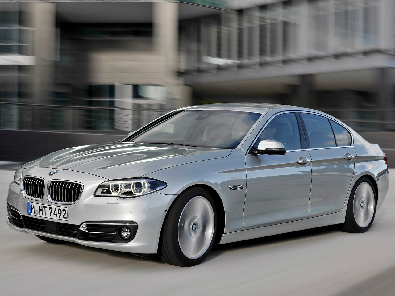 BMW 5-я серия седан (F10 рестайлинг, 2013 - 2016 г.в.): вид спереди сбоку в движении в городе