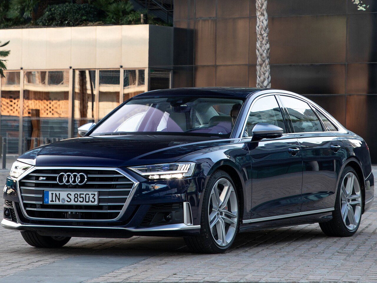 Audi S8 седан (D5, 2019 - 2022 г.в.): вид спереди сбоку у здания