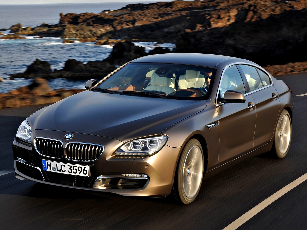 BMW 6 серия Гран Купе 4.4 xDrive AT 650i: вид спереди сбоку на береговой дороге