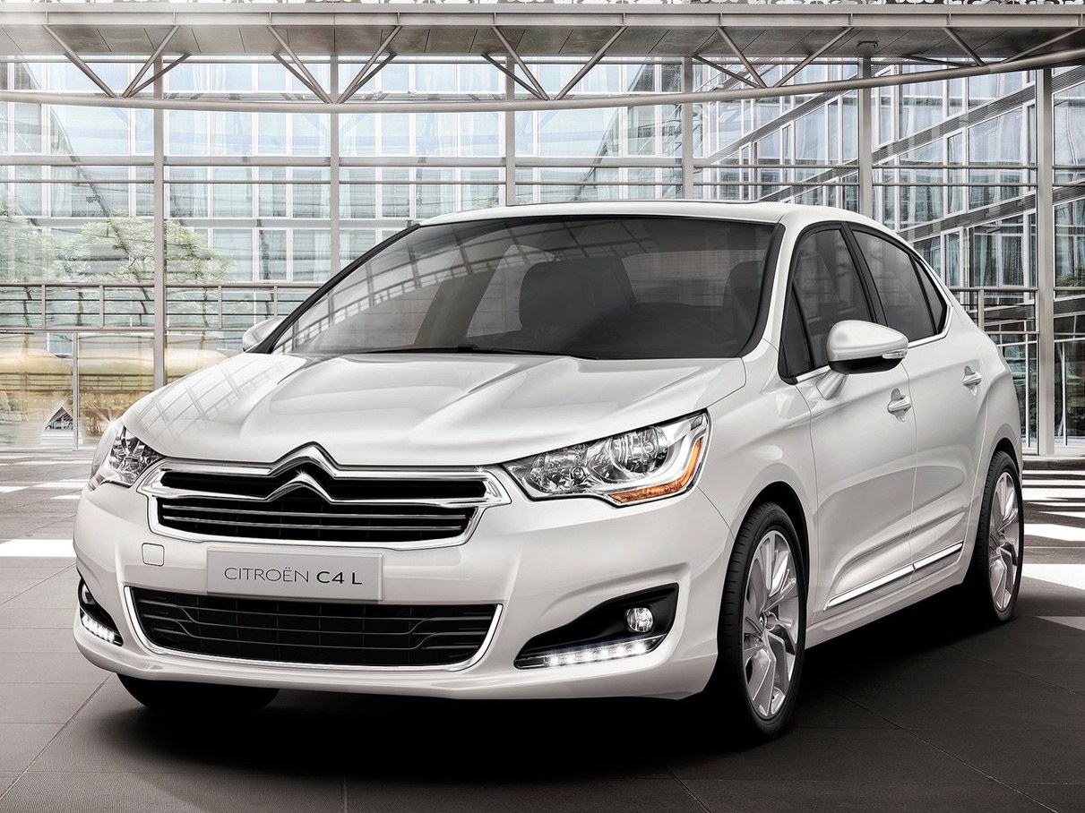 Citroen C4 седан (II поколение, 2013 - 2016 г.в.): вид спереди сбоку у здания