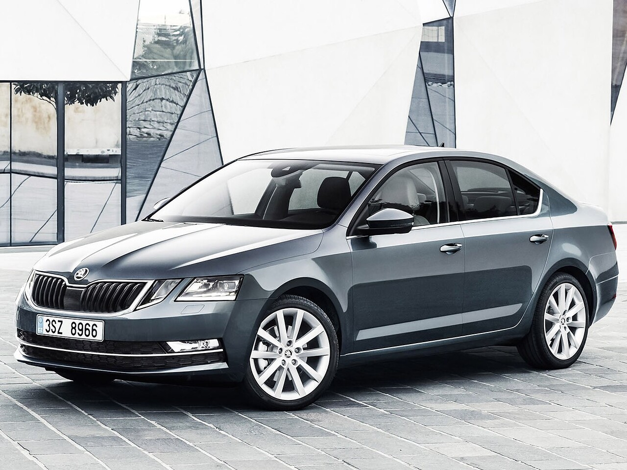 Skoda Octavia лифтбек (III поколение рестайлинг, 2016 - 2020 г.в.): вид спереди сбоку у здания