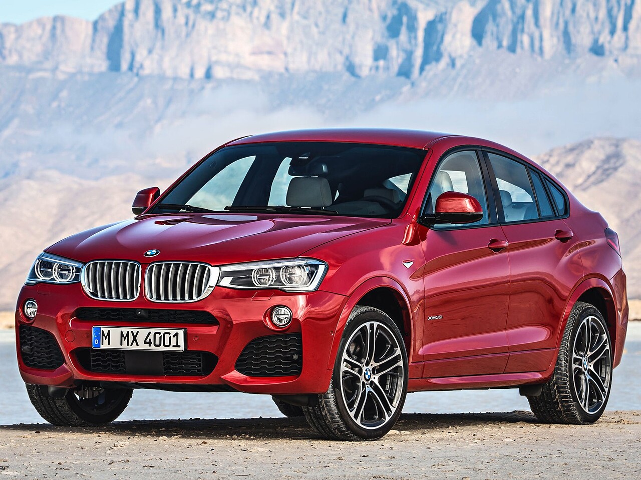 BMW X4 (F26, 2014 - 2018 г.в.): вид спереди сбоку на фоне гор
