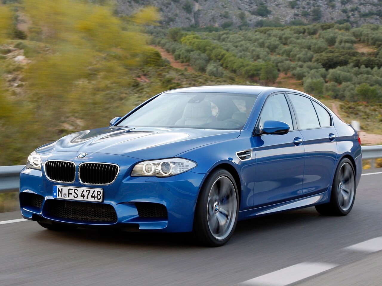 BMW M5 седан (F10, 2011 - 2013 г.в.): вид спереди сбоку в движении