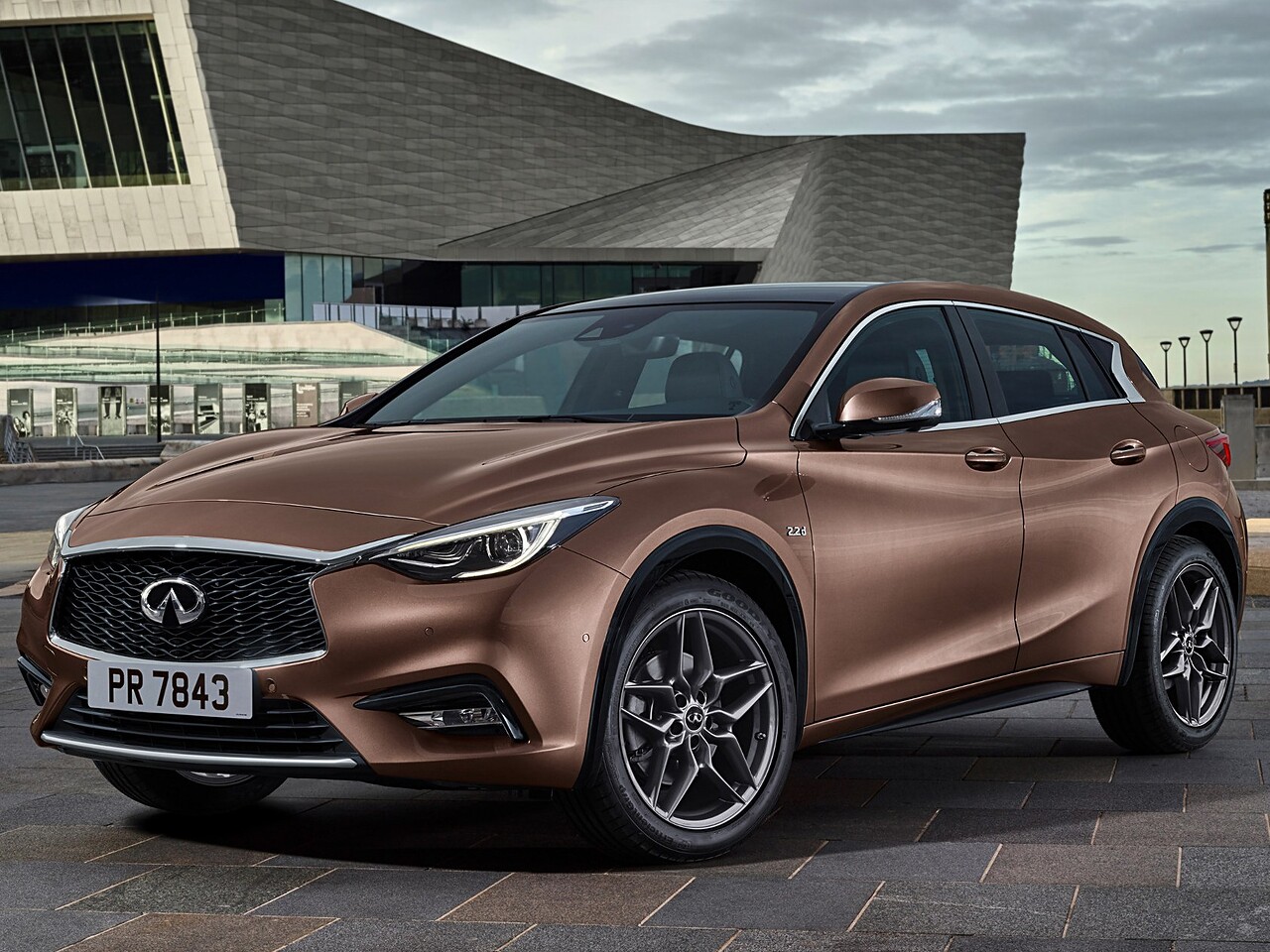 Infiniti Q30 (I поколение, 2016 - 2019 г.в.): вид спереди сбоку у здания