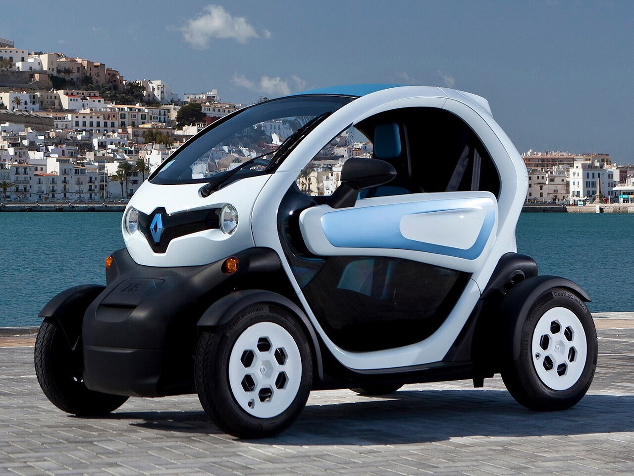 Renault Twizy (I поколение, 2016 - 2022 г.в.): вид спереди сбоку на фоне города