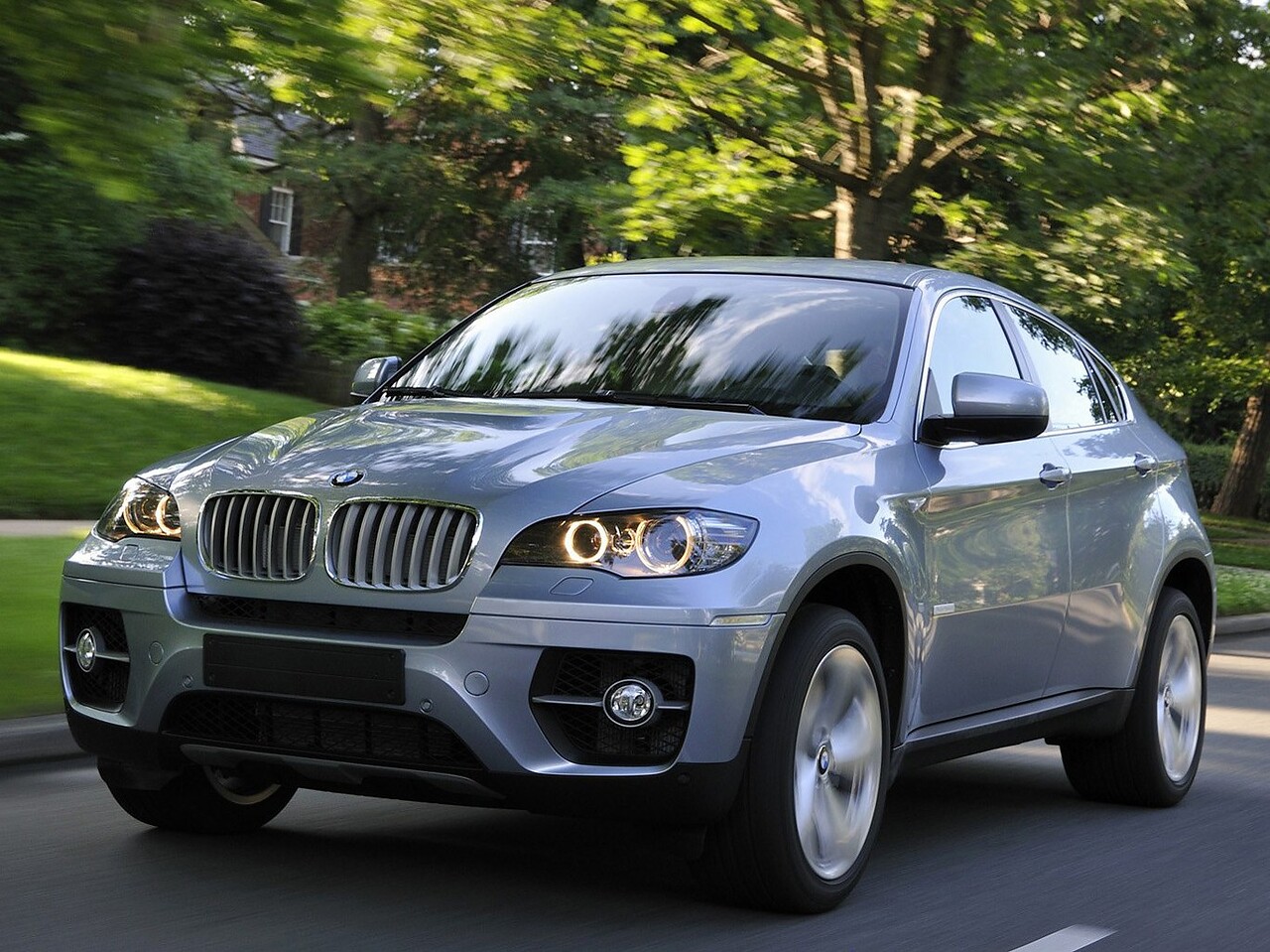 BMW X6 ActiveHybrid (E71, E72, 2009 - 2012 г.в.): Кроссовер в движении на дороге в лесу