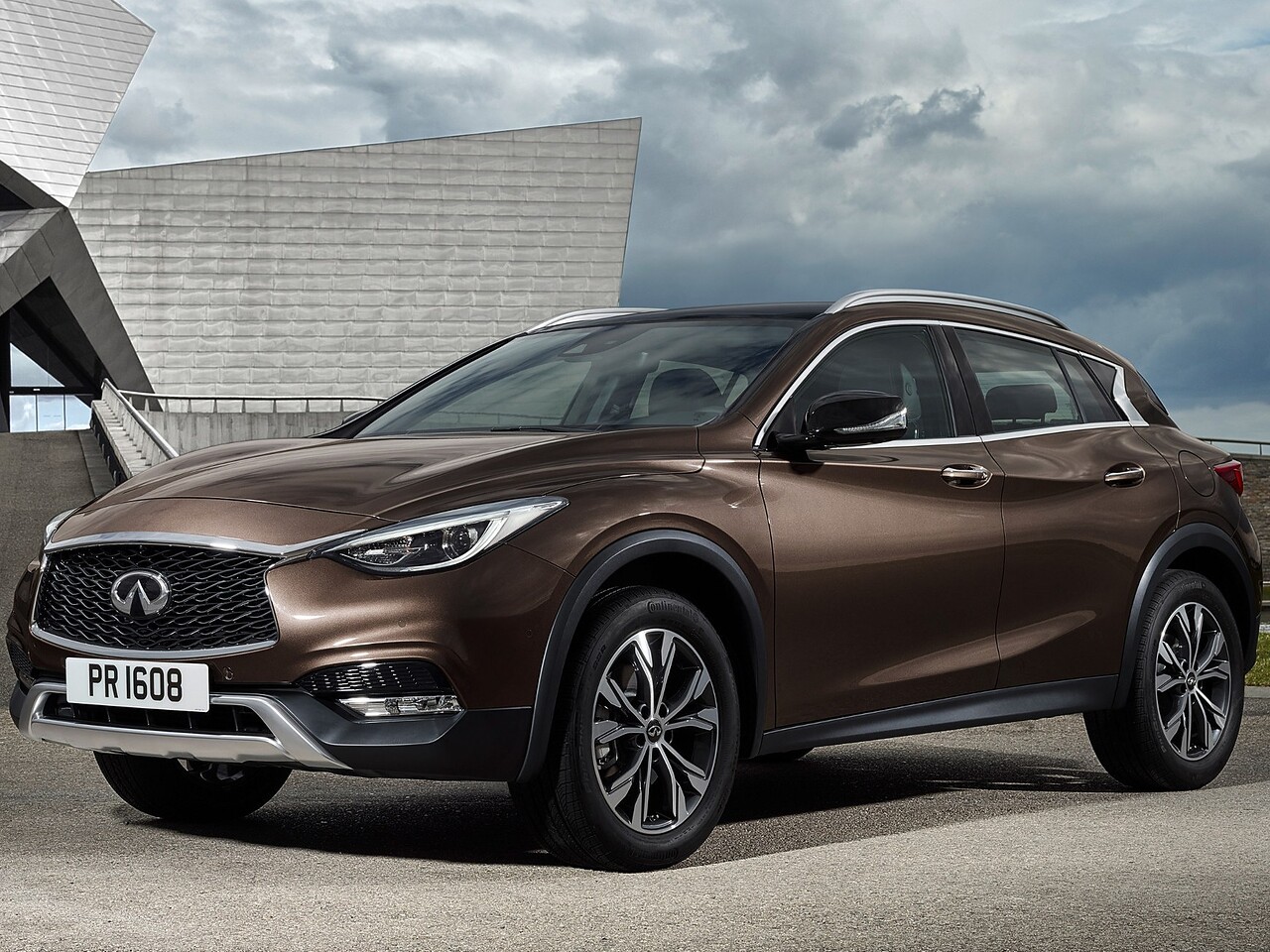 Infiniti QX30 (I поколение, 2016 - 2019 г.в.): вид спереди сбоку у здания