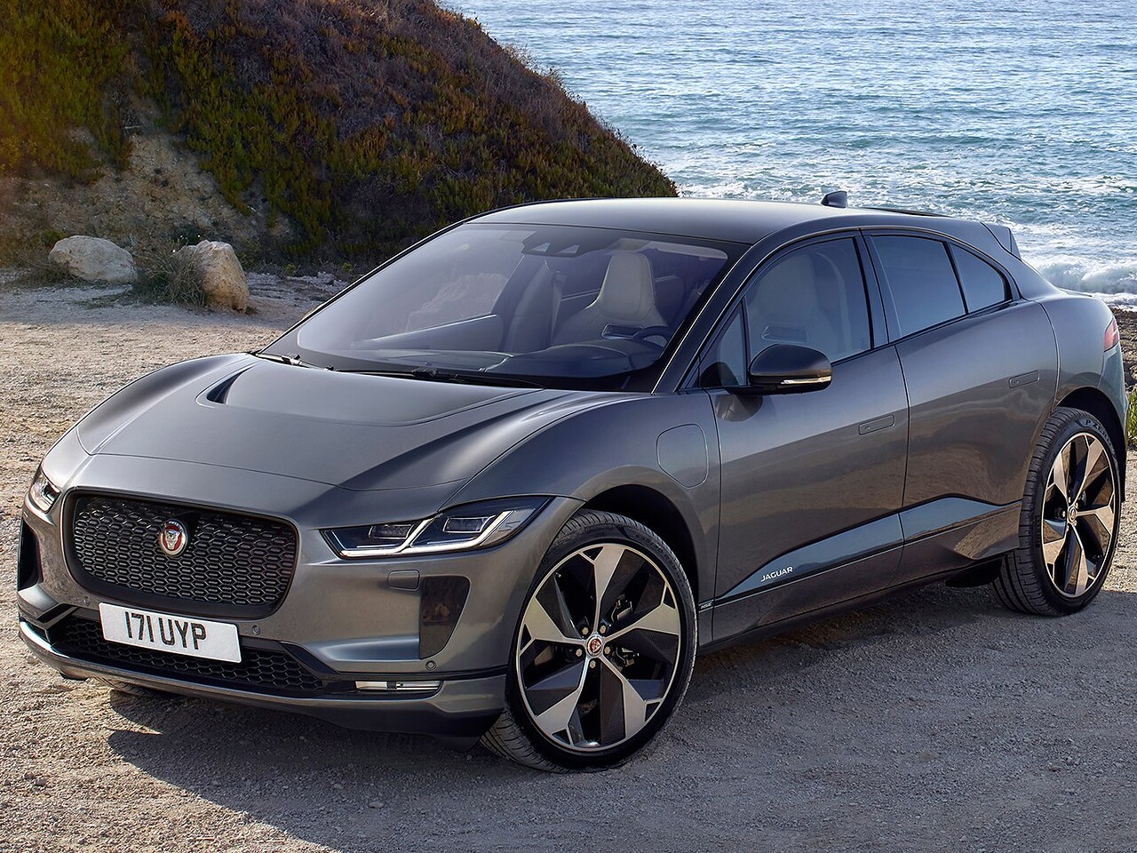 Jaguar I-Pace (I поколение, 2018 - 2022 г.в.): вид спереди сбоку у воды