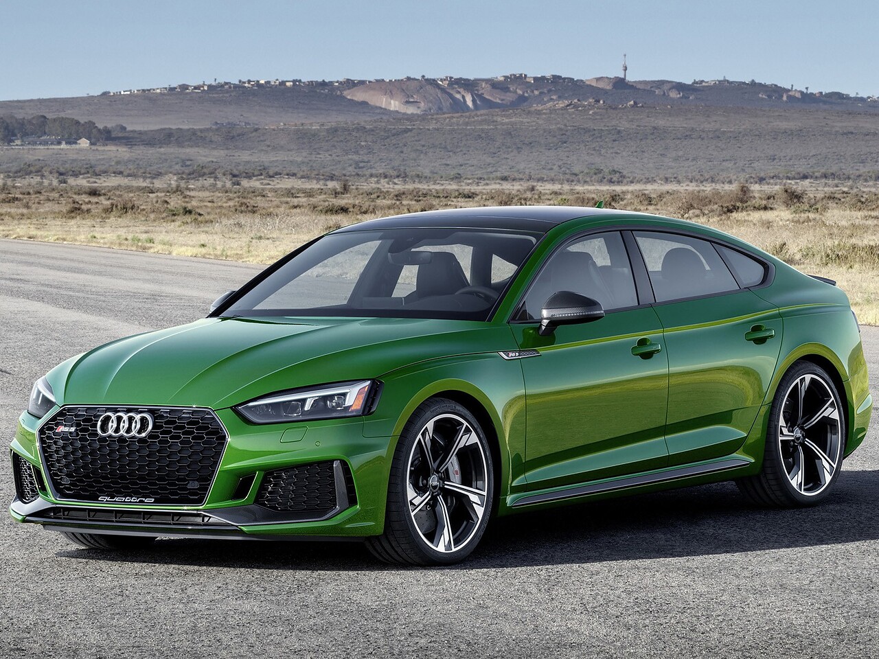 Audi RS5 лифтбек (II поколение, 2018 - 2020 г.в.): вид спереди сбоку на фоне гор