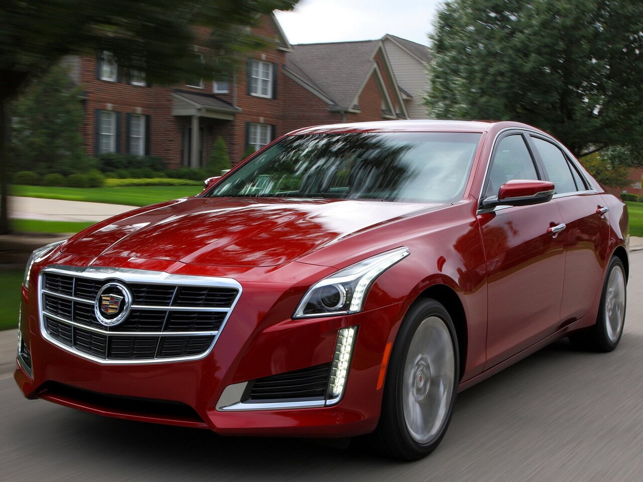 Cadillac CTS седан 3.6 AT Premium V6: Красный седан у кирпичного дома в пригороде