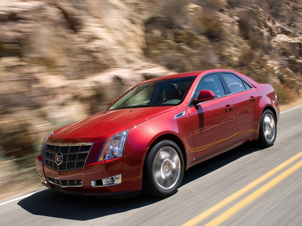 Cadillac CTS седан (II поколение, 2008 - 2014 г.в.): Красный седан на горной дороге в движении