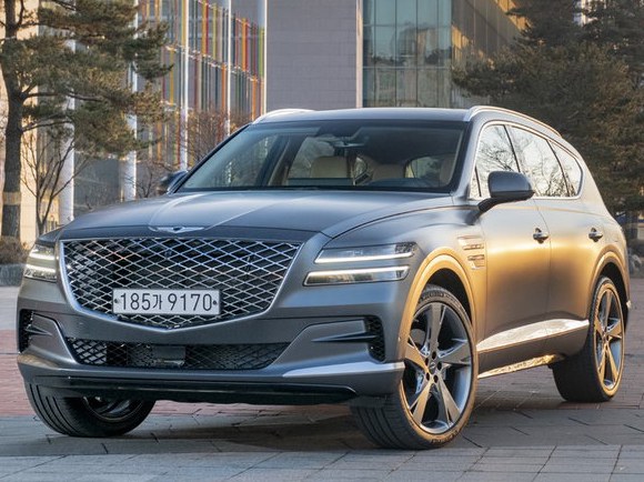 Genesis GV80 кроссовер (I поколение, 2020 - 2022 г.в.): вид спереди сбоку у зданий