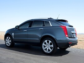 Cadillac SRX (II поколение, 2010 - 2014 г.в.): Тёмно-серый кроссовер на открытой площадке, вид сзади