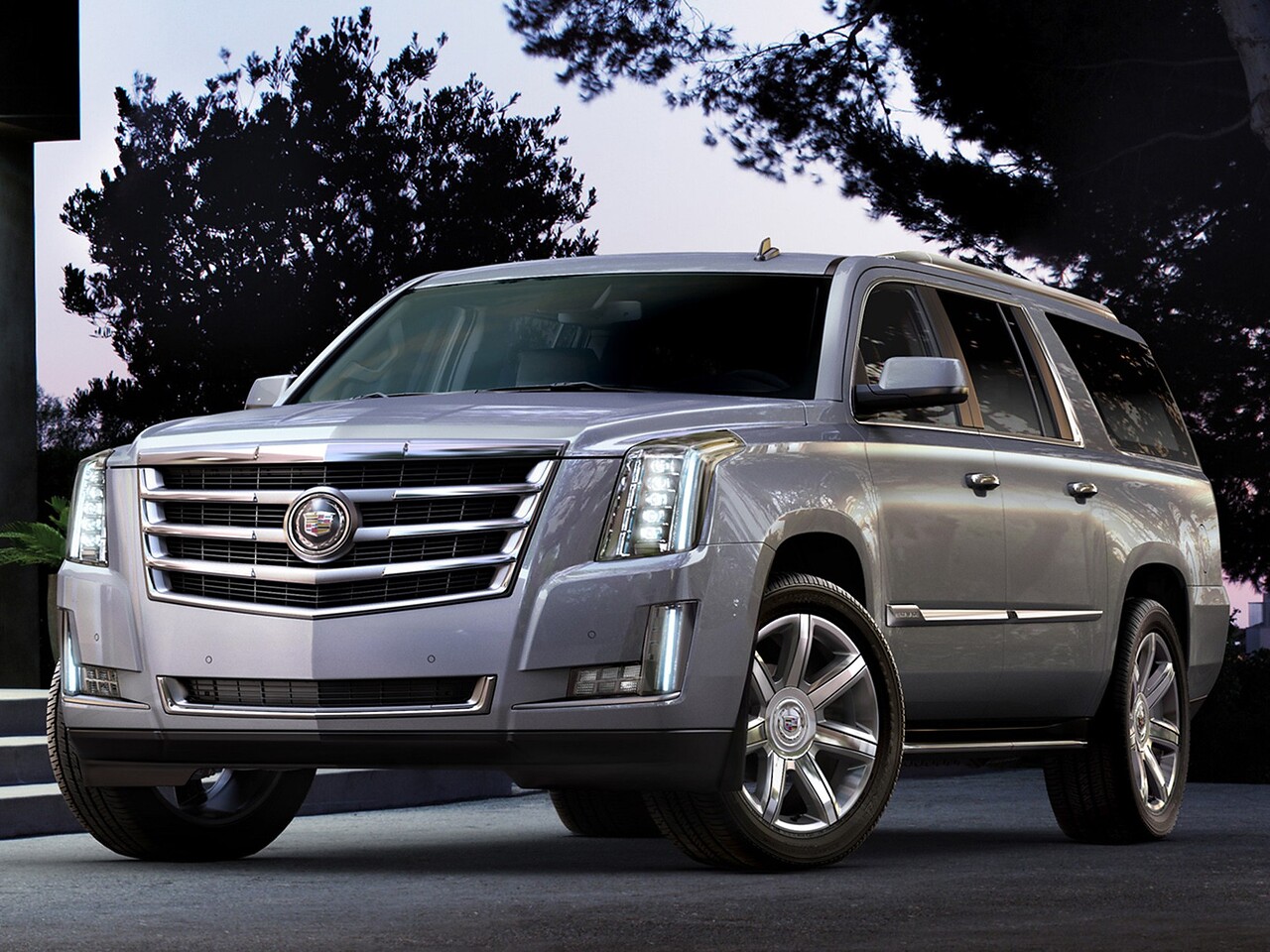 Cadillac Escalade (IV поколение, 2015 - 2021 г.в.): Серебристый внедорожник у современного здания с остеклением