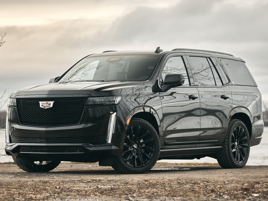 Cadillac Escalade: Тёмный внедорожник на открытой местности, вид спереди