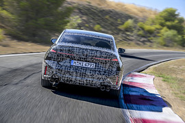 BMW рассказала о новой «тройке» с режимом дрифта: прототип в повороте, вид сзади