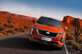 Cadillac начал продажи гибрида XT5 в Китае: вид спереди сбоку на дороге
